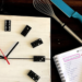 utensílios de cozinha, um caderno e um relógio