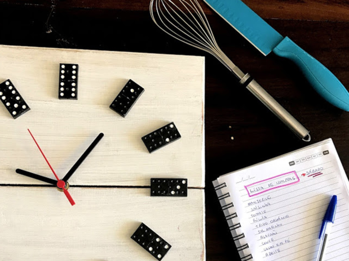 utensílios de cozinha, um caderno e um relógio